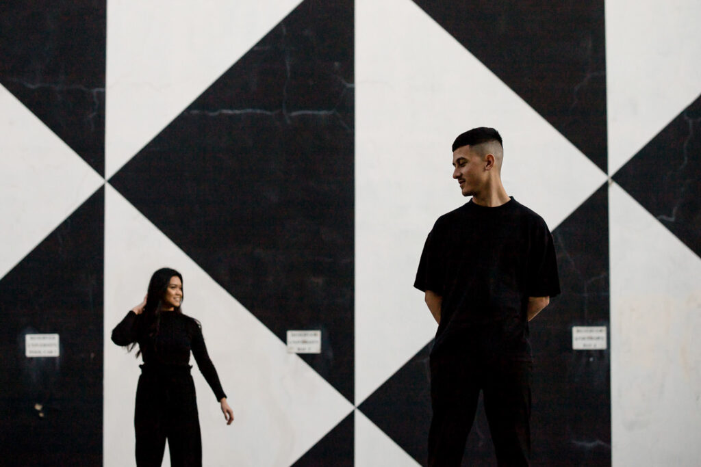 Couple posing at a modern pre-wedding shoot location in Fremantle, Perth, with a black-and-white geometric wall.