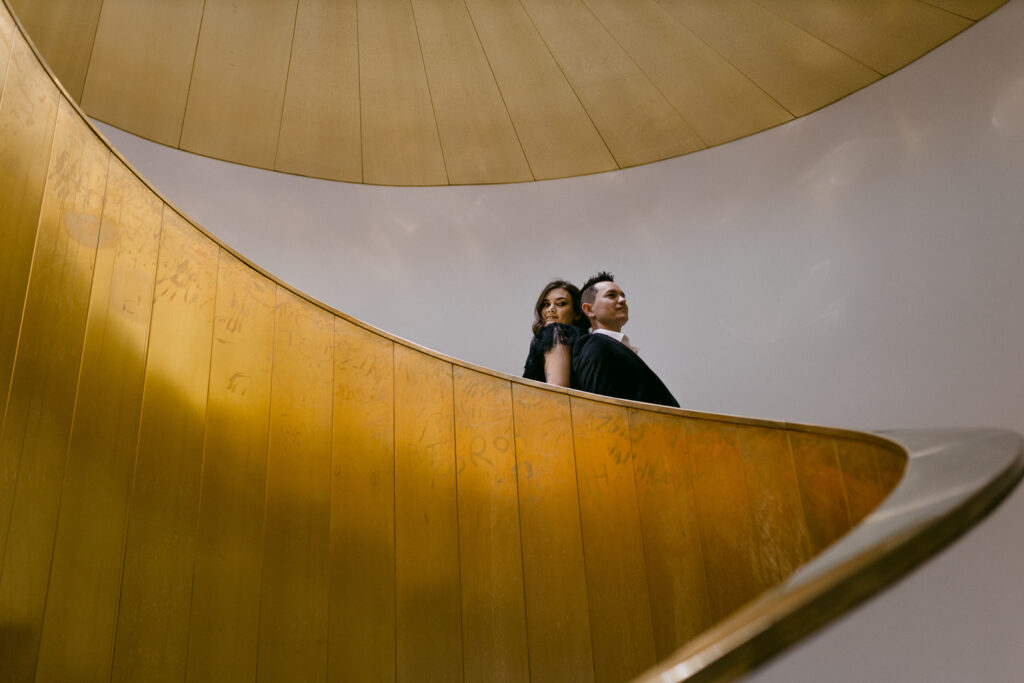 Stylish couple posing on a golden spiral staircase during a pre-wedding shoot in Perth.