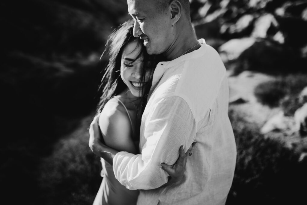 Singapore couple embracing and smiling during their Perth pre-wedding photoshoot in black and white