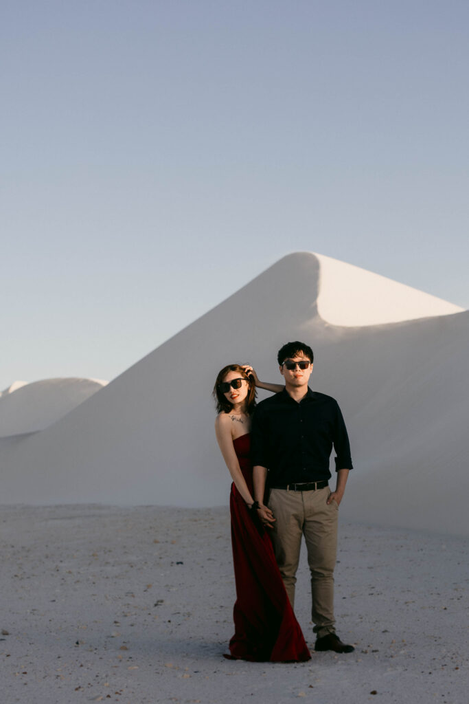 couple standing together in fron of sand dunes for their perth pre-wedding photo session