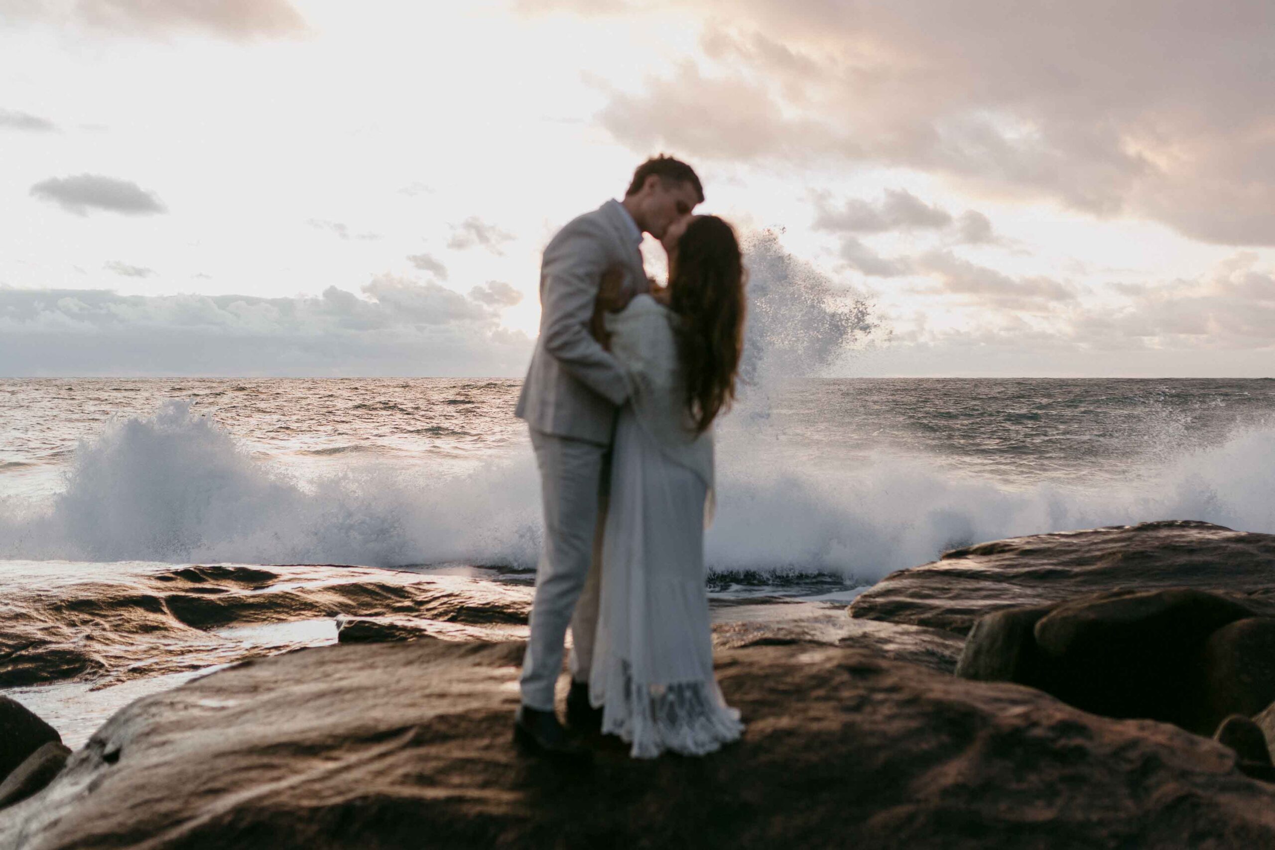 Hannah and Jake embracing on the rocky coast during their Margaret River elopement