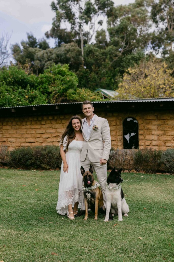 Newlyweds posing with their dogs outside the private chapel