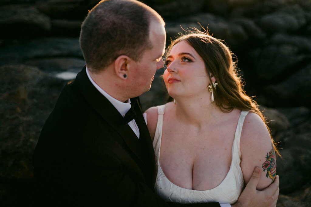 couple looking into each others eyes with sun rim lighting them in the background at prevally beach margaret river for their pre-wedding shoot