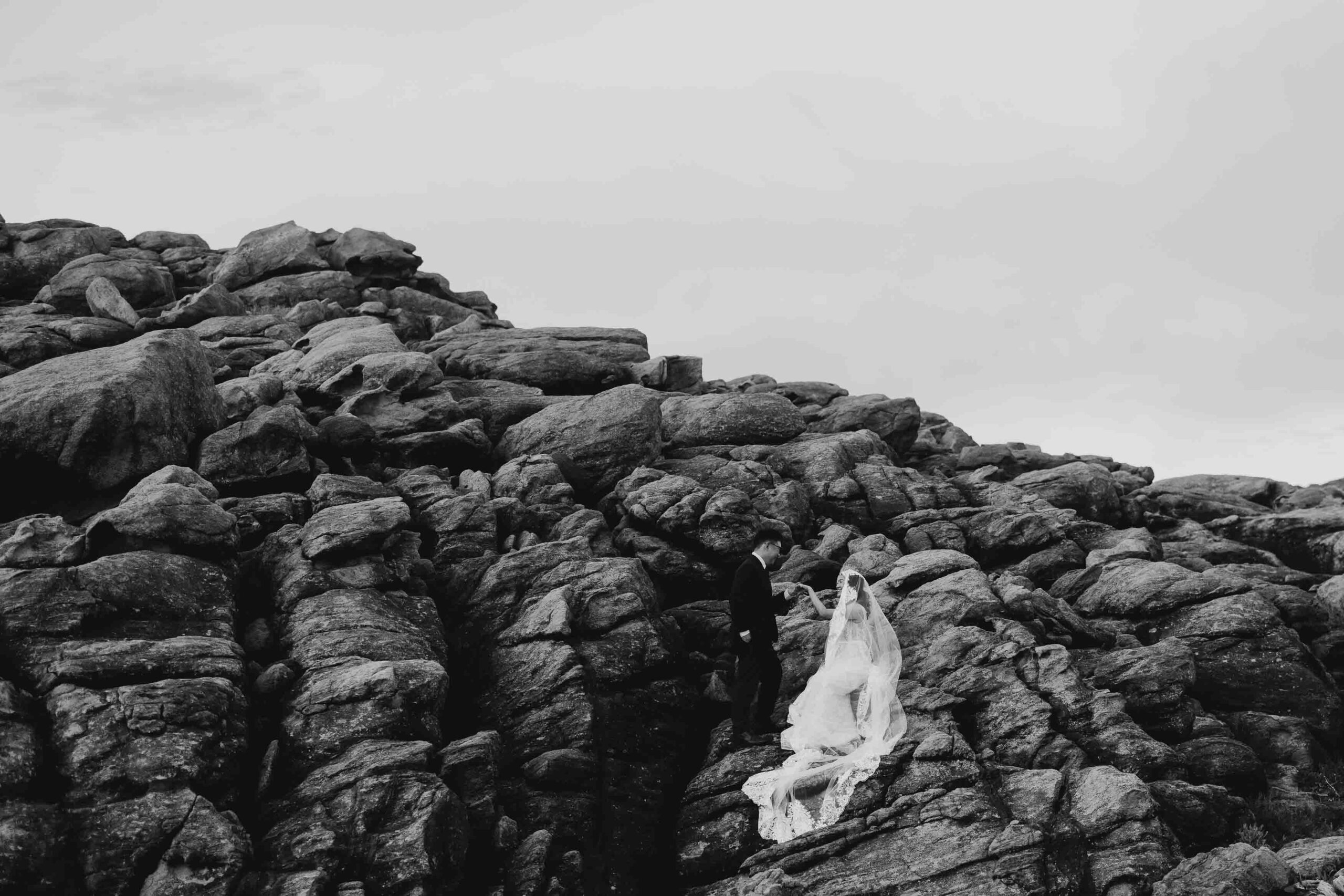 Black and white photo of couple relaxing on the rocks of INjidup Spa in Yallingup