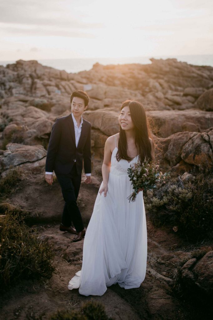 Flora and Kennet walking together to their next location at Injidup spa for their pre-wedding photos