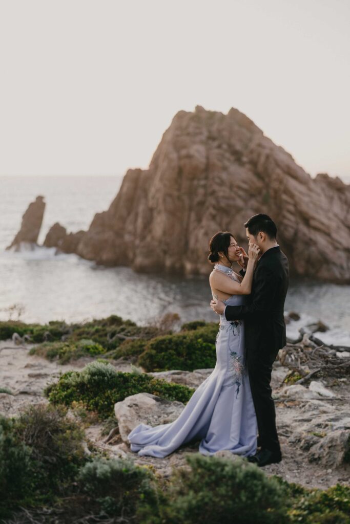 Couple embracing during a windy Sugarloaf Rock sunset shoot