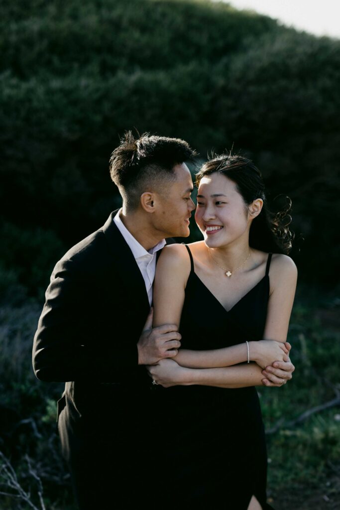 Davis leaning close to Joey as she smiles during their Sugarloaf Rock pre-wedding shoot