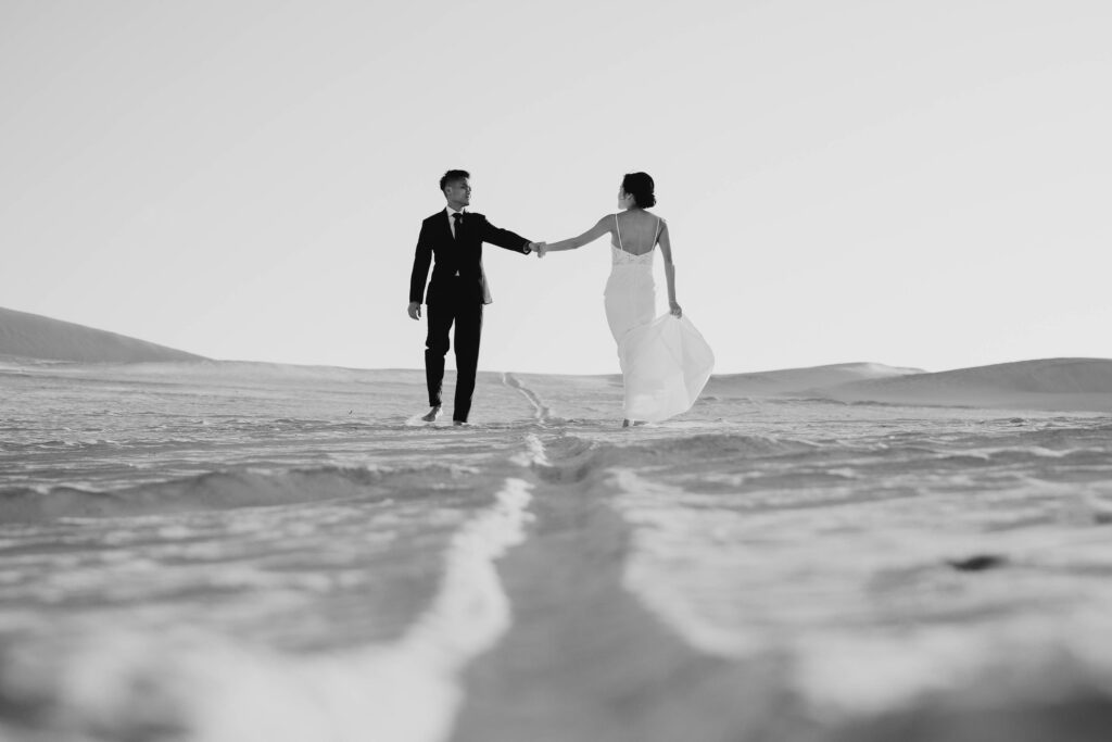 Joey and Davis walking barefoot through Lancelin Sand Dunes in black and white