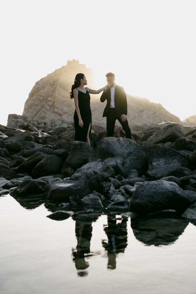 Joey and Davis walking beside a rock pool with their reflections beneath them