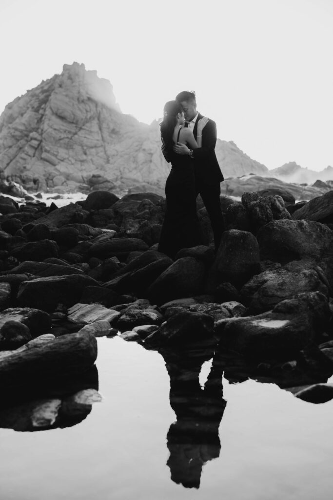 Joey and Davis reflected in a coastal rock pool in front of Sugarloaf Rock