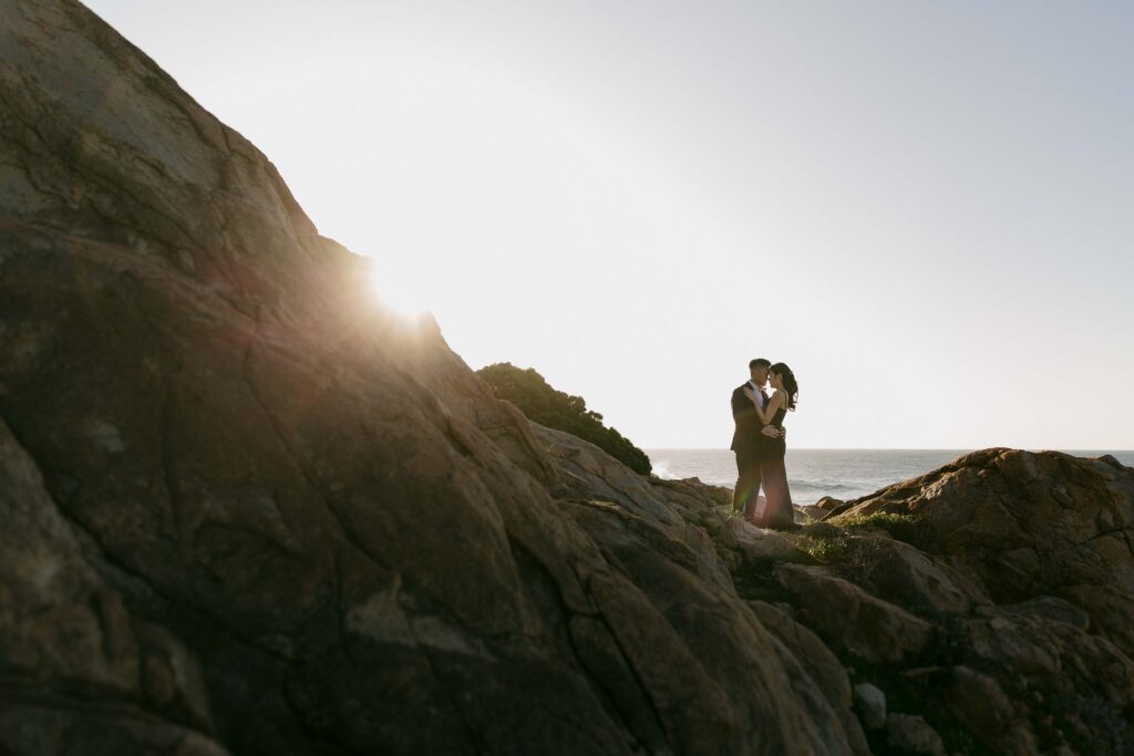 Joey and Davis standing together among sunlit rocks near Sugarloaf Rock