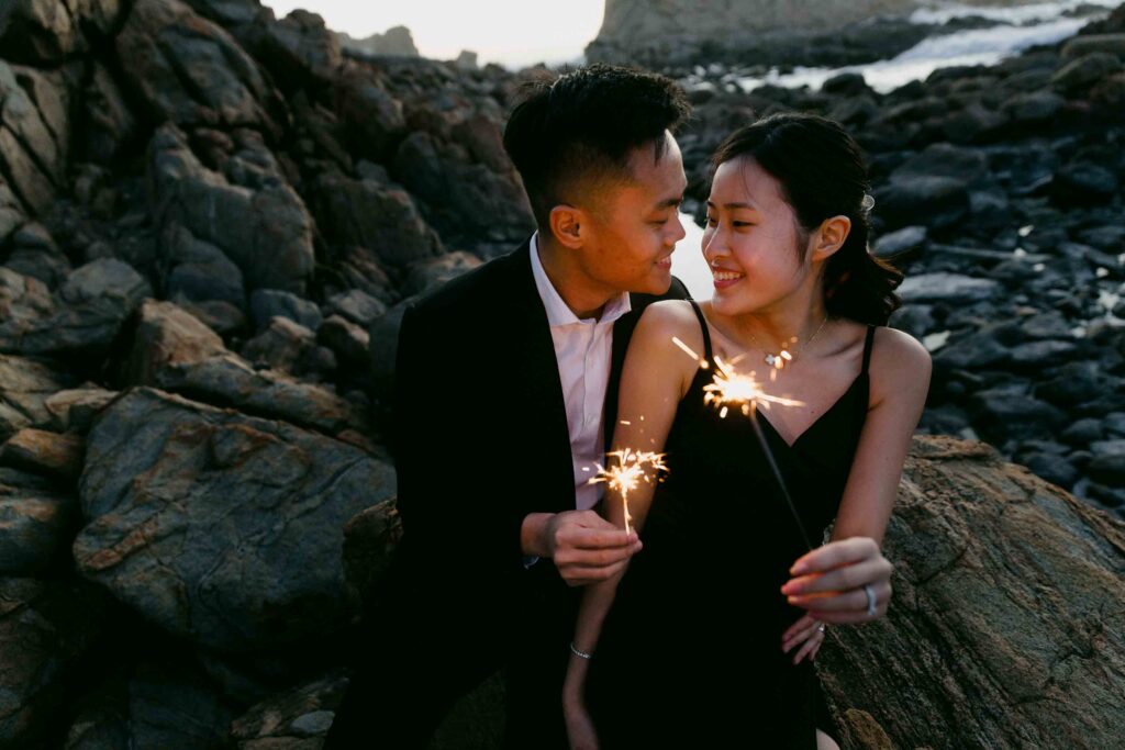 Joey and Davis smiling together while holding sparklers during their pre-wedding shoot