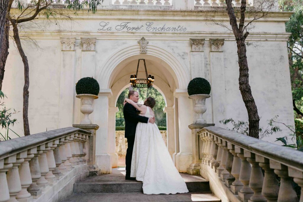 Bride and groom embracing at the steps of the La Foret entrance