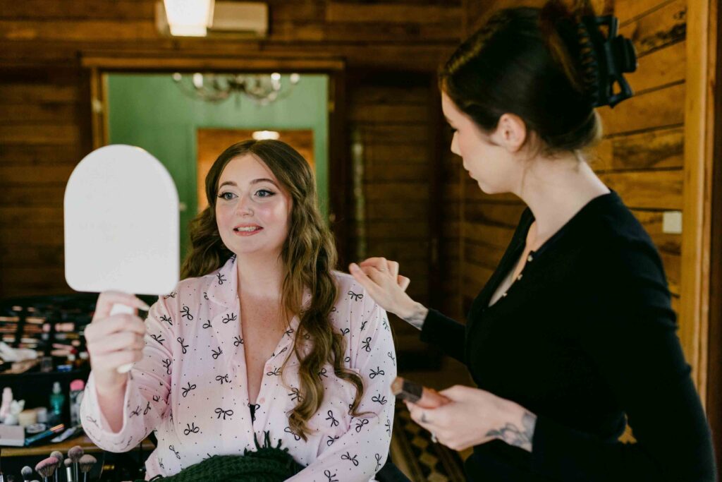 Bride getting ready looking at bake up through her mirror