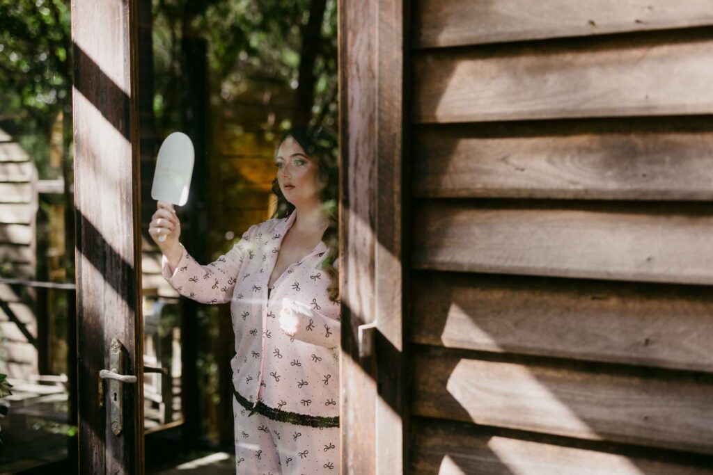 Bride getting ready looking at bake up through her mirror