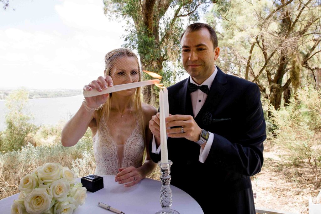Couple joining candle flames during their intimate Kings Park ceremony