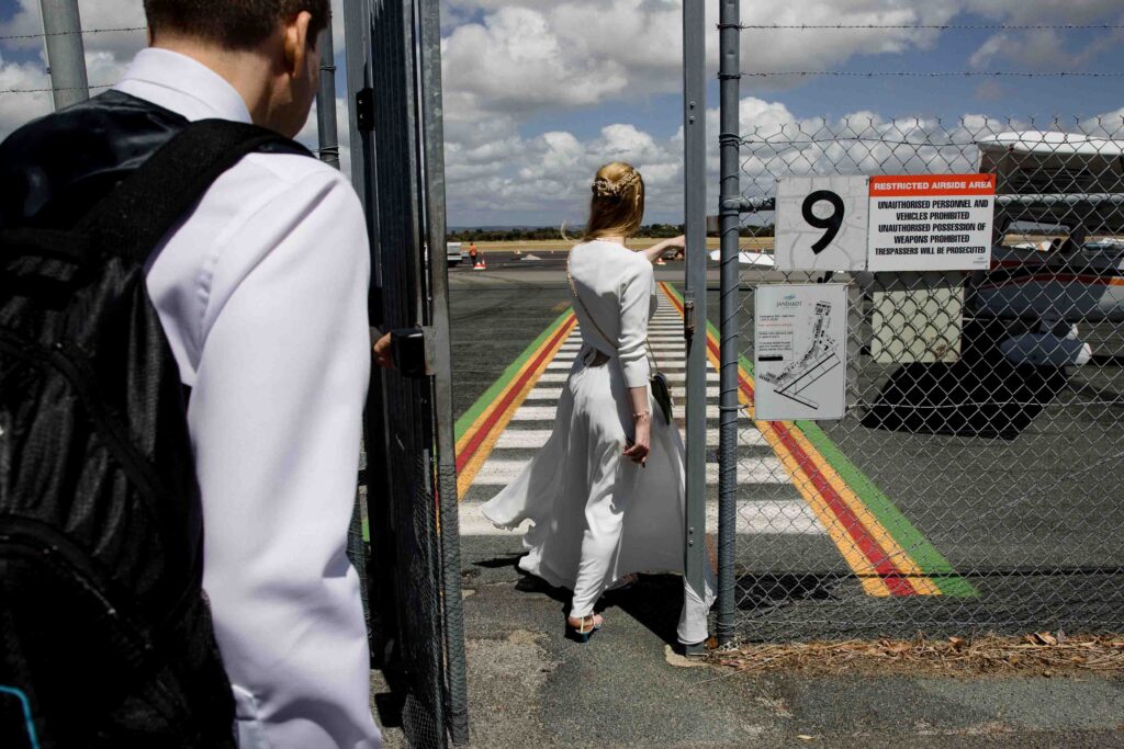 couple walking through the gates of the airport to their private plane after the micro-wedding in Kings Park 