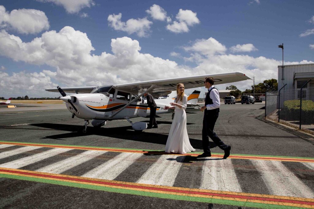 couple walking towards their private plane set for rottnest after the micro-wedding in Kings Park 
