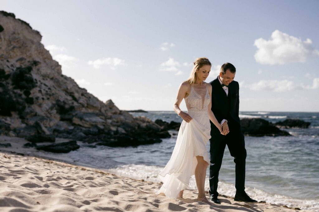 : Newlyweds walking along a quiet Rottnest Island beach
