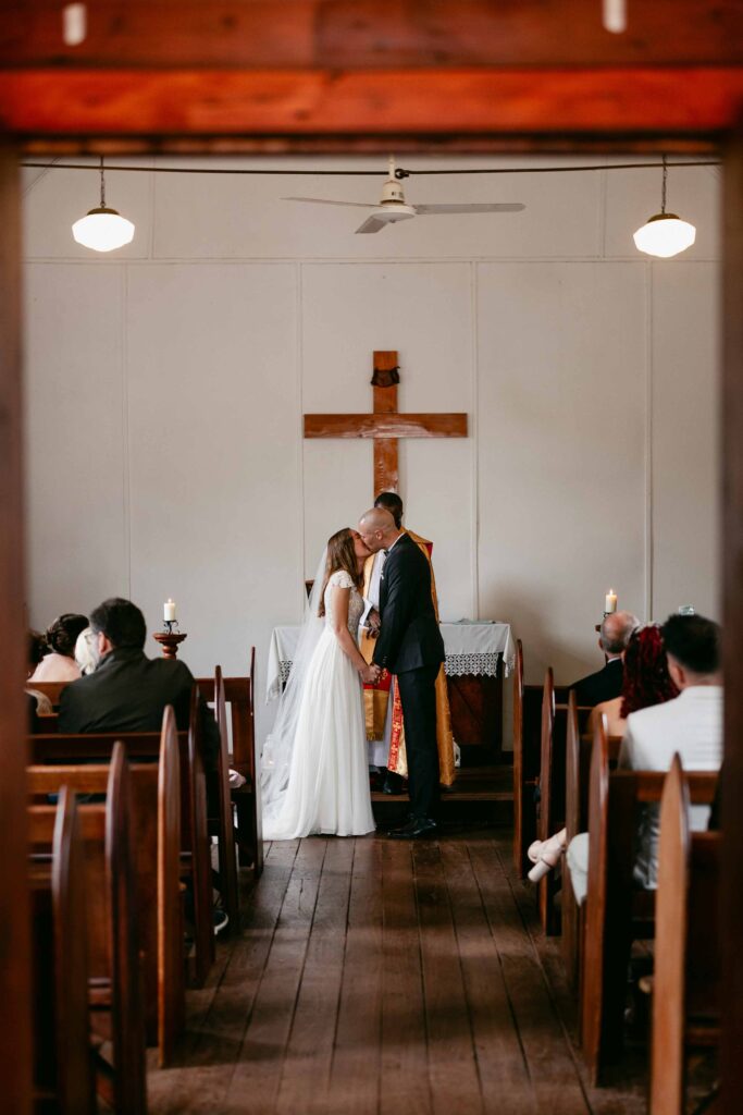 Newlyweds sharing their first kiss inside St Paul’s Anglican Church