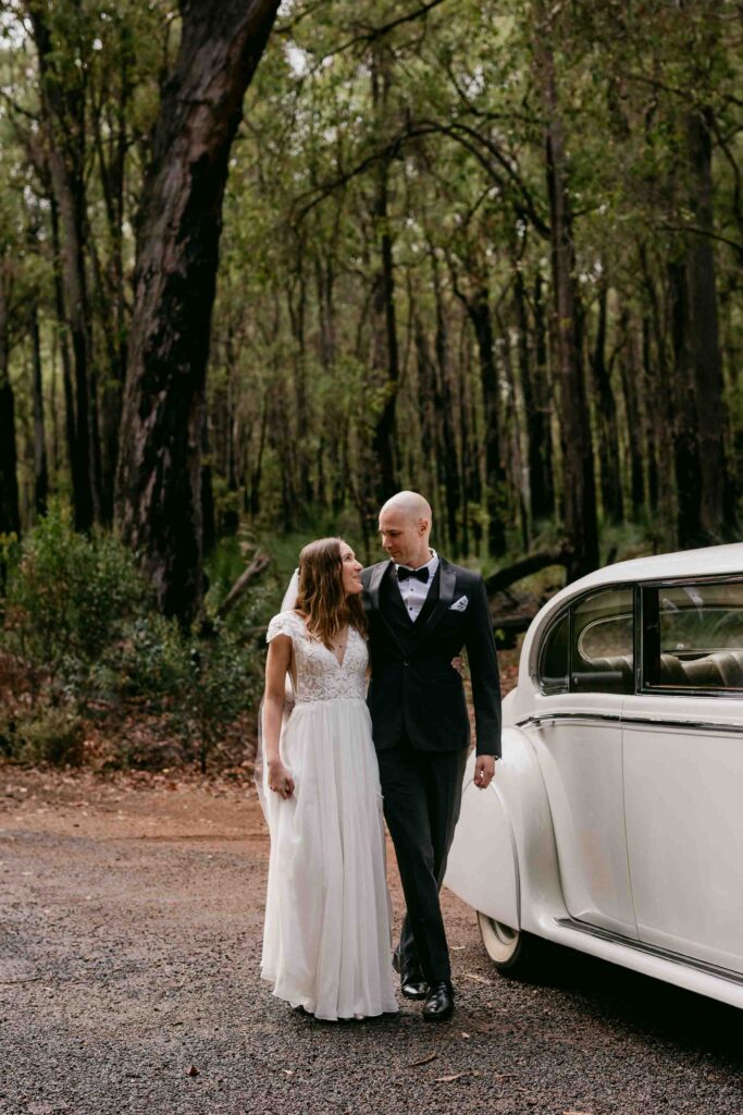 couple with belle wedding cars jaguar in the forrest