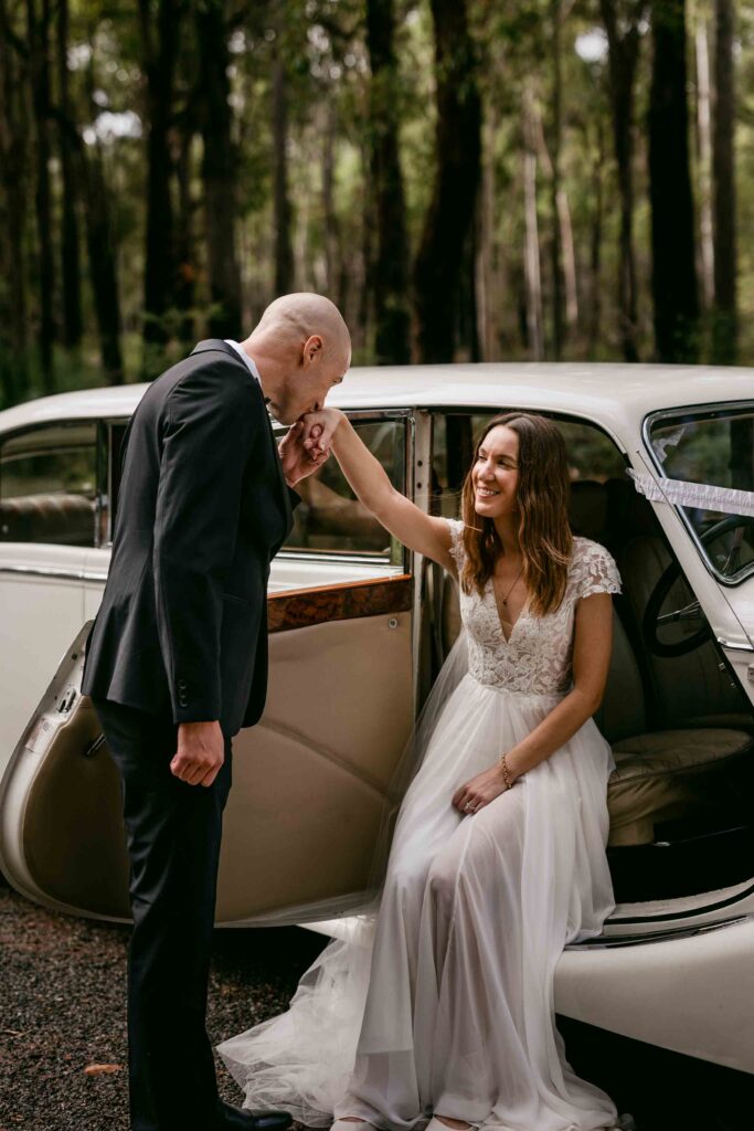 Bride and groom beside an ivory Jaguar Mk5 wedding limousine